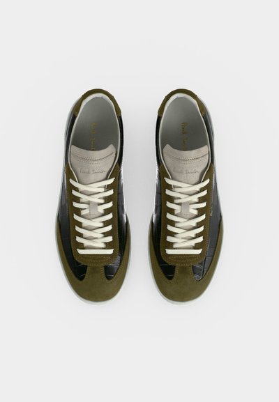 Paire de baskets vert olive et noir avec lacets blancs, panneaux en suède et cuir texturé crocodile, et languette beige avec le nom de la marque.