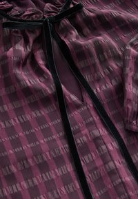 Bordo ruuduline pluus tekstuurse mustriga, millel on must sametist kaeluspael ja kergelt rüüs vööl.