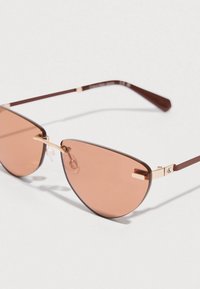Sončna očala z mačjim okvirjem, z rjavimi senčenimi lečami, tankimi rjavimi kovinskimi okvirji in zlatimi poudarki na mostu in stranici.
