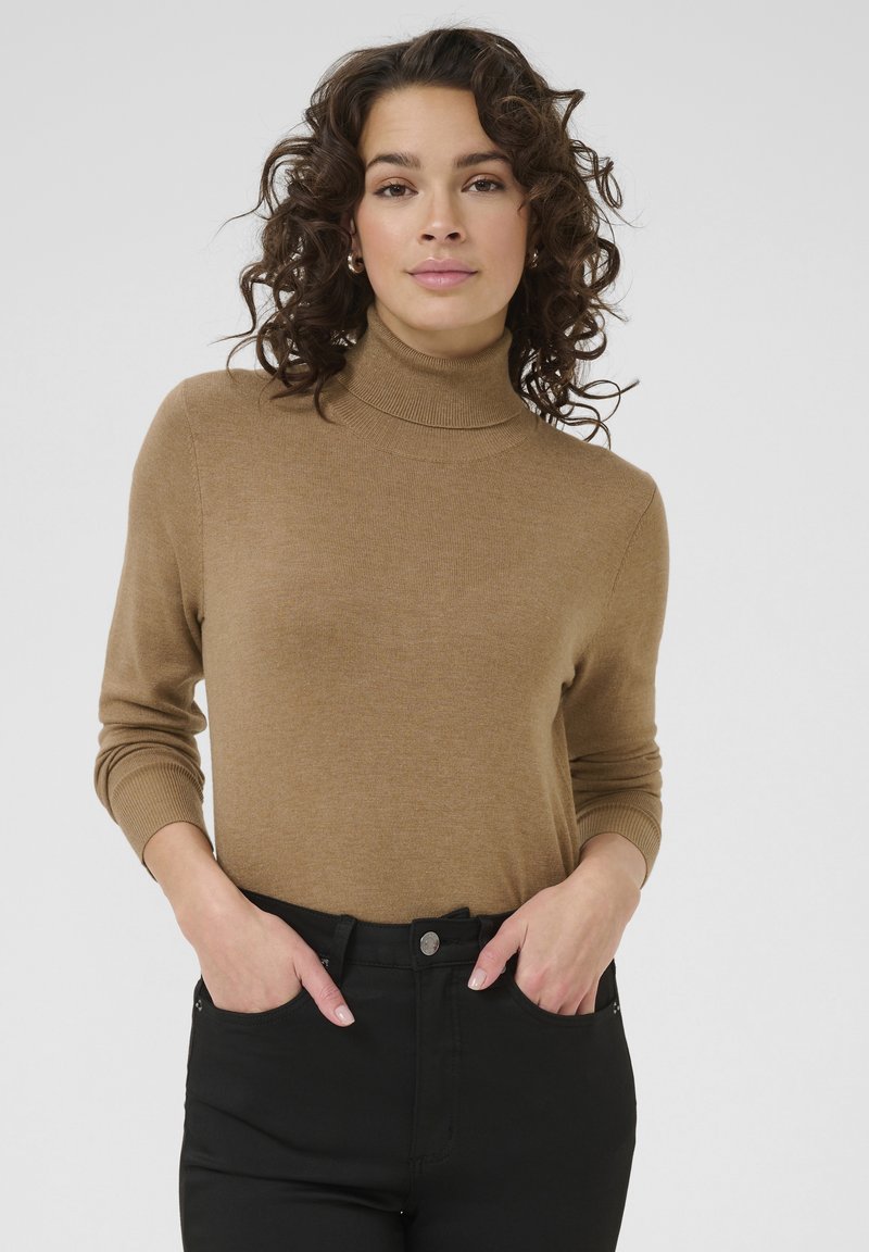 Brązowy sweter z golfem wykonany z miękkiego dzianinowego materiału, z długimi rękawami i ściągaczami, zestawiony z czarnymi spodniami.
