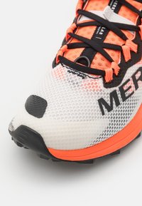 Chaussures de trail running avec un dessus en mesh blanc et des accents noirs, des lacets orange vif et une semelle noire texturée. Zone de orteil renforcée remarquable.
