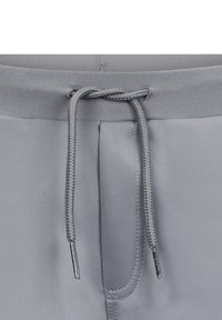 Pantaloni corti atletici grigi con cintura a cordoncino, texture morbida e tasche laterali con etichetta del marchio.