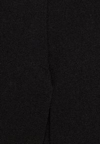 Černá texturovaná látka s tkaným vzhledem, vykazující hladký povrch a jednotnou barvu. Žádné viditelné vzory ani akcenty.