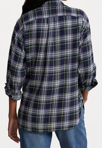 Rutig skjorta i flanell med mönster i blått, grönt, vitt och gult. Långa ärmar uppkavlade; spetsig krage; avslappnad passform.