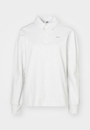 Polo a maniche lunghe in cotone grigio chiaro. Presenta un colletto classico, una riga di bottoni e un discreto logo Nike dorato sul petto.
