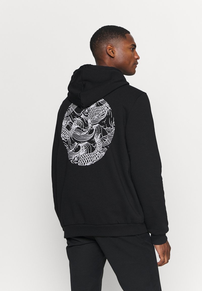 Black hoodie featuring a large, intricate white dragon graphic on the back. Made from soft fabric with a relaxed fit and a drawstring hood.