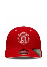 Rote Baseballmütze mit dem weißen, auf der Vorderseite gestickten Manchester United Logo und Produktstickern auf dem Schirm.