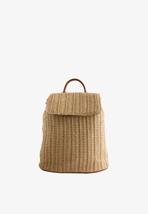 Pletený ratanový batoh v béžové barvě s texturovaným povrchem, vybavený koženým držadlem a zavíráním na klopu. Jednoduchý, funkční design.