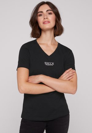 Schwarzes V-Ausschnitt-T-Shirt aus weichem Stoff mit einem kleinen, weißen, gestickten Logo auf der linken Brust. Kurze Ärmel, normale Passform.