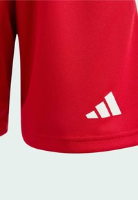 Pantalones cortos deportivos rojos hechos de un material suave y transpirable. Presentan el logo blanco de Adidas y un dobladillo limpio.