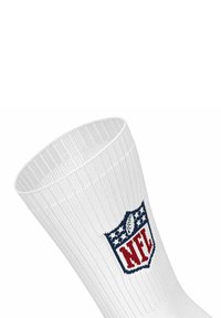 Calcetín deportivo blanco de canalé que presenta un logotipo de la NFL en azul y rojo con estrellas y un diseño de balón de fútbol en el puño. Textura de fibra visible.