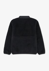 Crna flis jakna s mekanom teksturom, dugim rukavima i zaobljenim ovratnikom. Ima glatku završnu obradu na ovratniku i jednostavan dizajn.