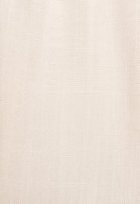 Tessuto intrecciato color beige chiaro con una superficie fine e texture. Il materiale appare morbido e traspirante, mostrando un sottile motivo a griglia.