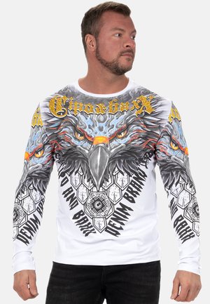 Long-sleeve white shirt featuring detailed eagle graphic with bright yellow and black accents, hexagonal patterns, and bold text designs.
