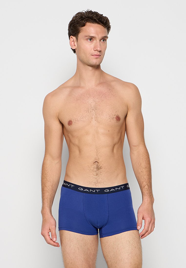 Herrblå boxershorts tillverkade av bomull. Har en svart elastisk midja med vit text. Slät textur och åtsittande design.