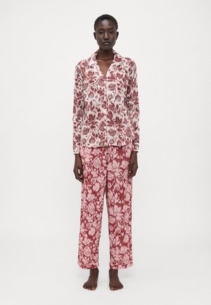 Bloemmotief pyjama-set in bordeauxrood en crème, met een lange mouw button-up top en losvallende broek met een vergelijkbaar ontwerp.
