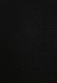 Tissu noir avec une surface lisse et légèrement texturée. Présente un motif serré et des détails de couture minimalistes le long des bords.