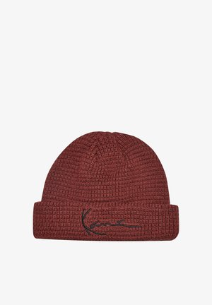 Bonnet bordeaux en maille gaufrée avec revers et signature brodée noire sur le revers avant sur fond blanc.