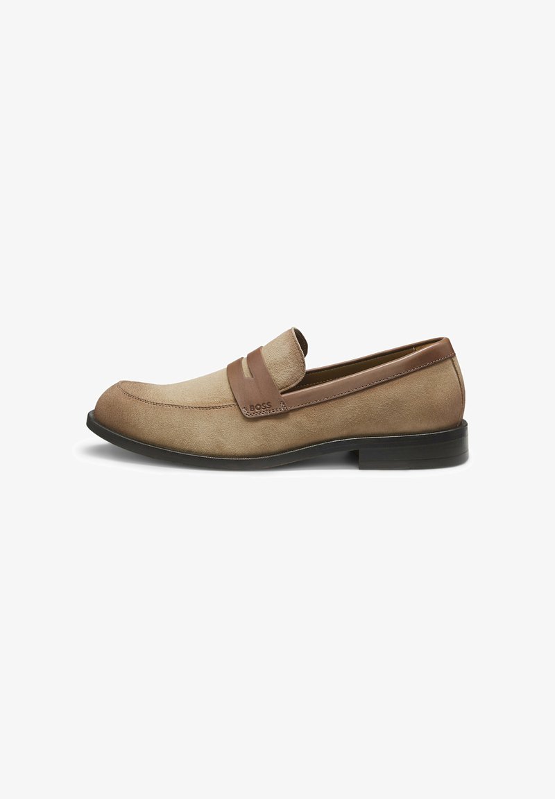 Mocassin pour hommes en daim couleur tan avec une lanière en cuir marron et une semelle noire, design élégant avec un bout arrondi, marqué "BOSS" sur la lanière.