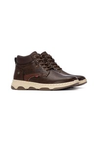 Zapatos altos de cuero marrón con un cuello acolchado, suela de goma tostada y cordones marrones. Presenta un pequeño logotipo de acento en contraste en el lateral.