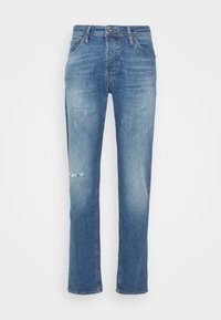 Calças de ganga de denim azul claro com um design de perna reta, apresentando remendos desgastados e um acabamento ligeiramente desvanecido. Presas por uma cintura padrão e botão.