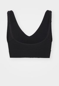 Svart bralette med V-ringad design, justerbara axelremmar och en mjuk tygstruktur. Har en sömlös band nederst för stöd.