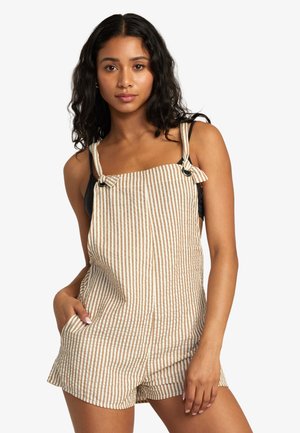 Salopette a righe in misto cotone beige e bianco, dotata di spalline regolabili a cravatta e tasche, con una vestibilità rilassata e lunghezza pantaloncino.