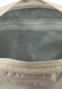 Borsa in tessuto chiaro con interno in rete, dotata di chiusura a zip e sottile motivo a griglia all'esterno. Texture liscia.