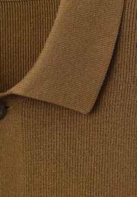 Cardigan lavorato a maglia marrone con una texture a coste, un colletto ripiegato e dettagli con bottoni. Il materiale sembra morbido e flessibile.