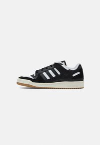 Zwarte suède en leren sneaker met witte strepen, ronde neus en gumrubberen buitenzool. Beschikt over een gewatteerde kraag en een gebrandmerkte hielstrip.
