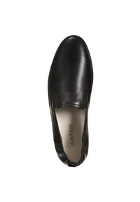 Chaussure noire sans lacets en cuir lisse, avec des panneaux élastiques sur les côtés et une semelle en caoutchouc texturée. Intérieur marqué "Calvin Klein".