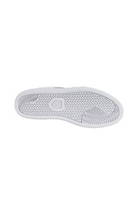 Suola di sneaker bianca con grip in gomma testurizzata, caratterizzata da un motivo a zig zag e da un emblema centrale. Design con bordi lisci e estremità arrotondata.
