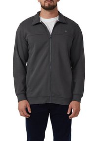 Giacca grigia con zip in un tessuto morbido, caratterizzata da un colletto alto e polsini a coste. Ha un design pulito con accenti minimi.