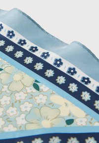 Μπλε μεταξωτό φουλάρι με λουλουδάτα και γεωμετρικά σχέδια, σε αποχρώσεις ανοιχτού και σκούρου μπλε. Οι άκρες έχουν ομαλή, διπλωμένη φινίρισμα.