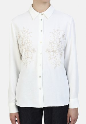 White long-sleeve shirt with a button-up front, featuring beige floral embroidery on the chest. Soft fabric with a classic collar and cuffs.