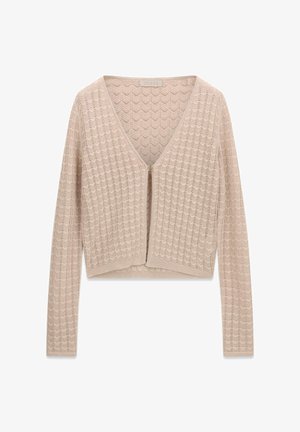 Beżowy sweter na drutach z długimi rękawami, dekoltem w serek, zapięciem na jeden guzik oraz wzorem ażurowym w kształcie jodełki na całej powierzchni.