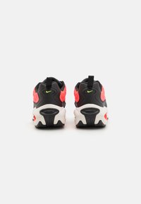 Black and neon pink sneakers with a textured upper, featuring a pull tab, cushioned sole, and prominent air cushioning detail.