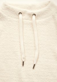 Sweatshirt beige clair avec une texture douce, présentant un col rond et des cordons blancs avec des embouts métalliques.