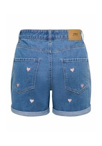 Short en denim bleu avec ourlets roulés, poches arrière et petites broderies de cœurs roses dispersées sur le tissu.