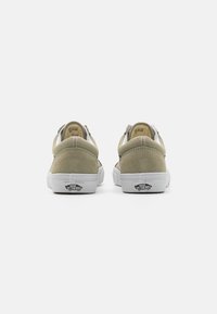 Light green suede sneakers with white rubber soles, featuring a padded collar, rear pull tab, and classic Vans logo on the heel.