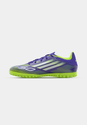 Purple and lime green soccer shoes with a textured design, featuring a lightweight upper, lace closure, and rubber outsole for traction.