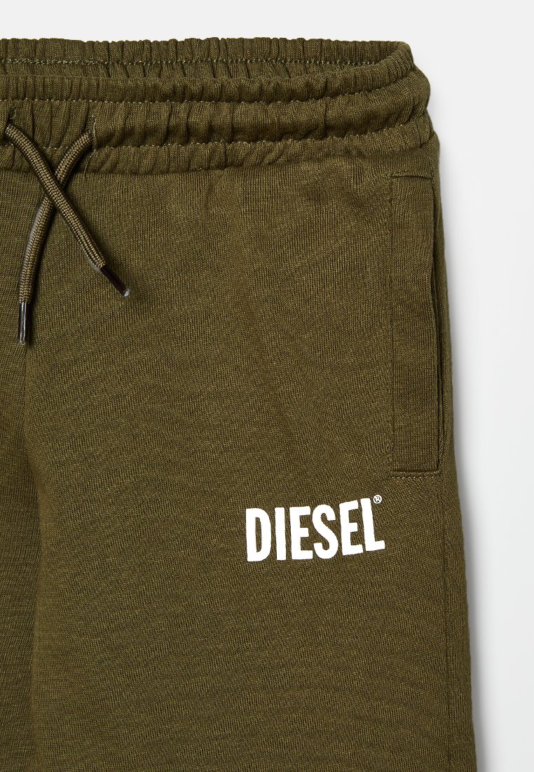 Oliwkowe dresy wykonane z miękkiego materiału, z elastycznym paskiem w talii, sznurkiem do regulacji i białym logiem "DIESEL" z boku.