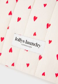 Quilted fabric pouch with a beige background and red heart patterns. Features a white label with "lollys laundry COPENHAGEN" printed in black.