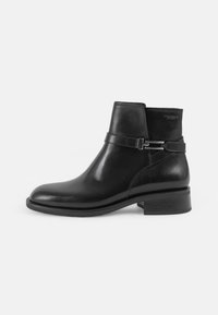 Sorte lær ankle boot med rund tå, mat finish, dekorativt remdetalj og lav blokkhelt. Sideglidelås for enkel påkledning.