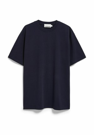 T-shirt en coton bleu marine avec une coupe décontractée, col rond, manches courtes et un petit logo ton sur ton sur la poitrine. Texture douce.