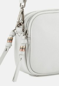 Borsa a tracolla bianca in pelle con finitura testurizzata, caratterizzata da accessori in metallo argentato e decorazioni sulla tracolla. Chiusura con zip nella parte superiore.