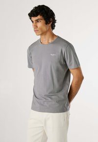 T-shirt grigio a maniche corte realizzato in tessuto morbido, con scollatura rotonda e piccolo logo bianco sul lato sinistro del petto.