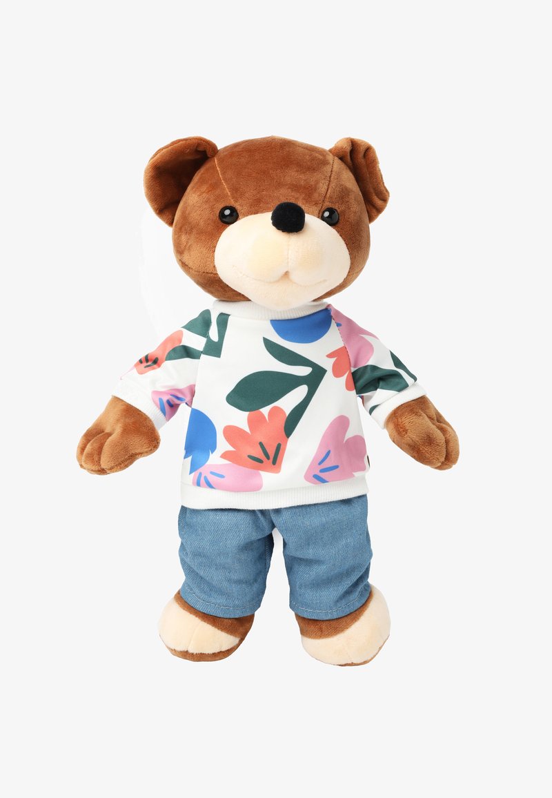Ours en peluche avec un visage et des pattes en fourrure brune. Il porte une chemise blanche à motifs floraux colorés et un short en jean bleu.