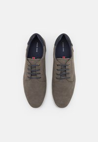 Chaussures en daim gris à lacets avec des accents marins, bout rond, détails perforés et semelle en caoutchouc blanc. Logo de la marque visible sur la semelle intérieure.