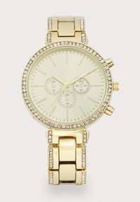 Gold chronograph watch with a round face. Features a cream dial, three sub-dials, and a bezel embellished with clear stones. Metal band links.